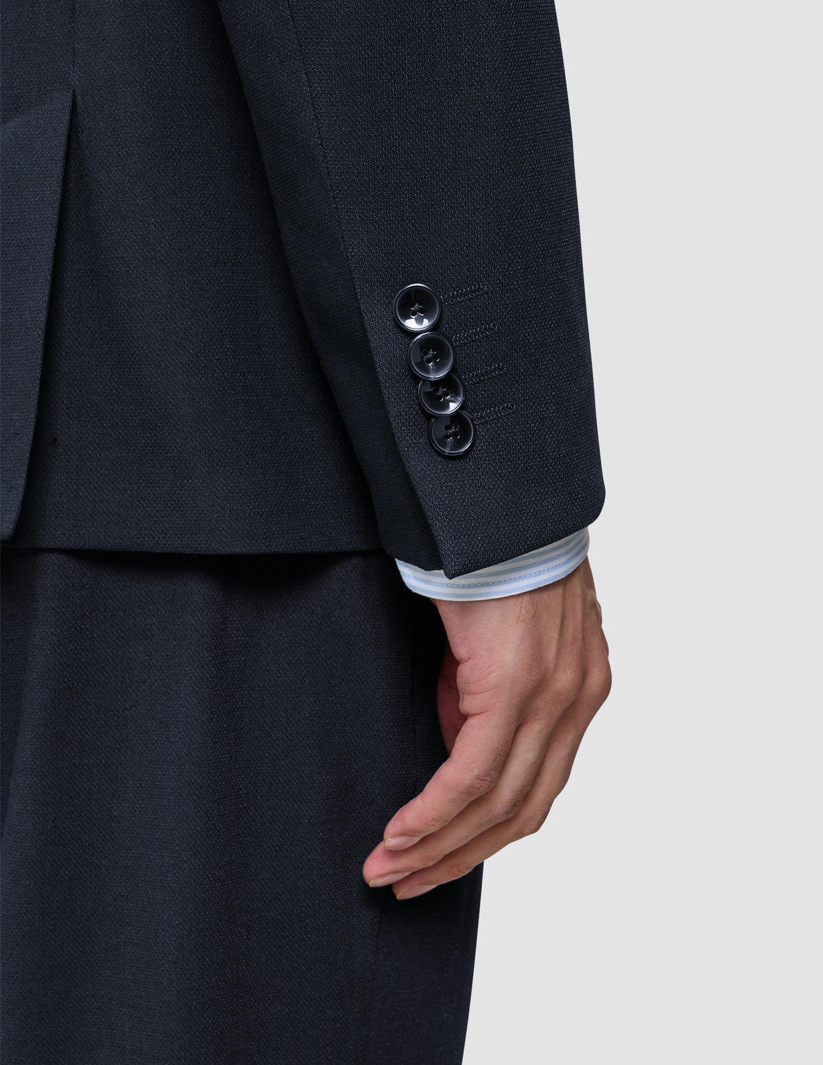 Närbild på en ärm från Motion Blazer Slim Midnight Blue, tillverkad i 360°-stretchtyg och med fyra knappar vid manschetten.