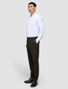 En man klädd i en vit skjorta med knappar och byxor av modellen Motion Suit Pants Regular Cognac med 360°-stretch.