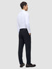 En man klädd i en vit skjorta och byxor av modellen Motion Suit Pants Regular Midnight Blue, sedd bakifrån.