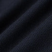 Närbild på vikta Motion Suit-byxor i storlek Regular, färgen Midnight Blue, med mörkblått strukturerat tyg och 360°-stretch.