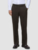 En person bär byxor av modellen Motion Suit Pants Relaxed Cognac, en vit skjorta med knappar och mörka läderskor av typen loafers.