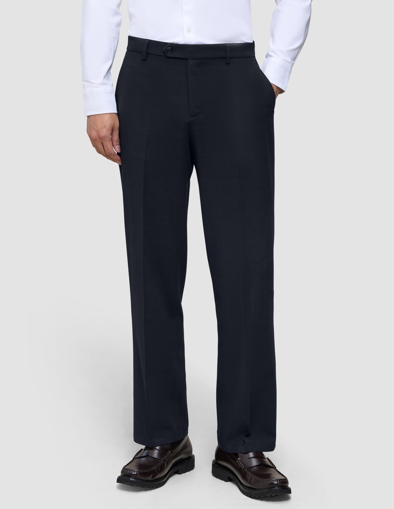 Motion Suit-byxor i avslappnad passform i midnattsblått, kombinerade med en vit skjorta och mörkbruna loafers.