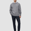 En man i en grå tröja, en vit skjorta med krage och midnattsblå Motion Suit Pants Slim samt loafers.