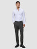 En man klädd i en vit skjorta, byxor av modellen Motion Suit Pants Slim Pepper Grey och svarta loafers, som speglar skandinavisk design.