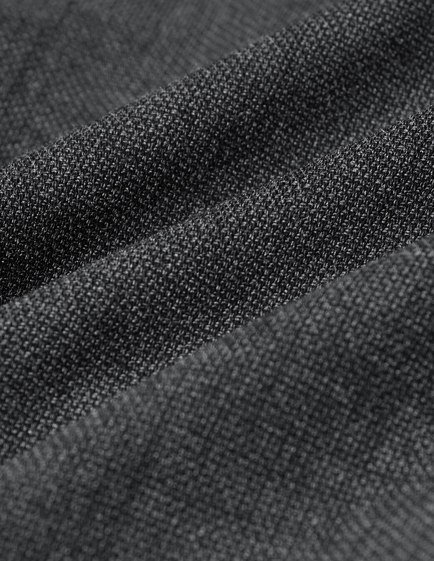 Närbild på den grå, finvävda strukturen på Motion Suit Pants Slim Pepper Grey.