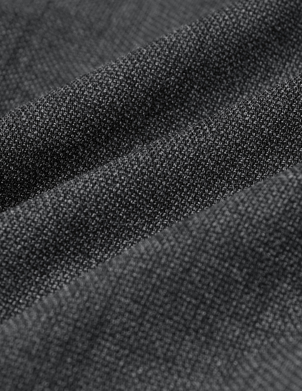Närbild på den grå, finvävda strukturen på Motion Suit Pants Slim Pepper Grey.