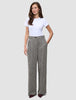 En kvinna bär en vit t-shirt och byxorna Women Ashryn Pants Wide Domino Herringbone i en skandinavisk stil.