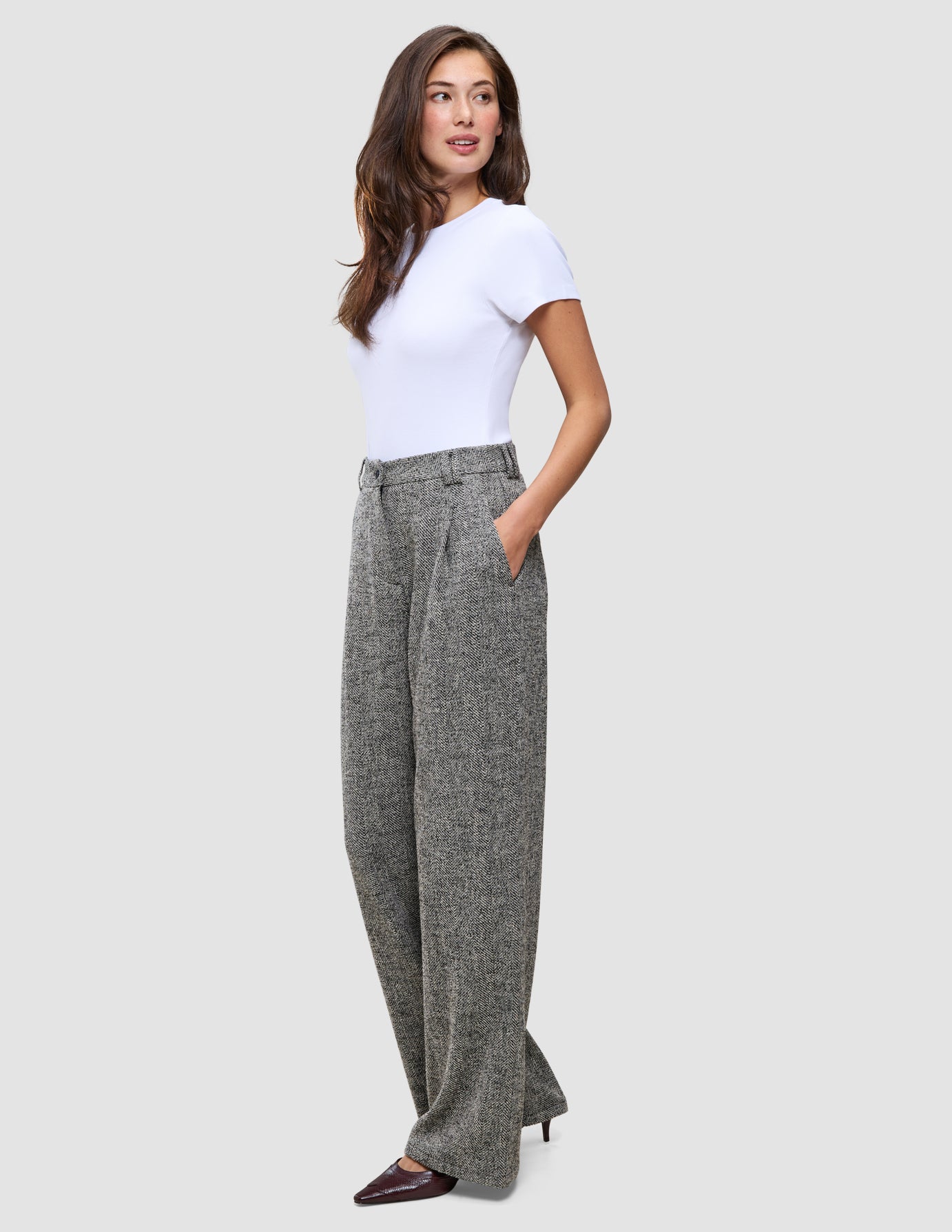 En kvinna klädd i en vit t-shirt och gråa Women Ashryn Pants Wide Domino Herringbone med hög midja.