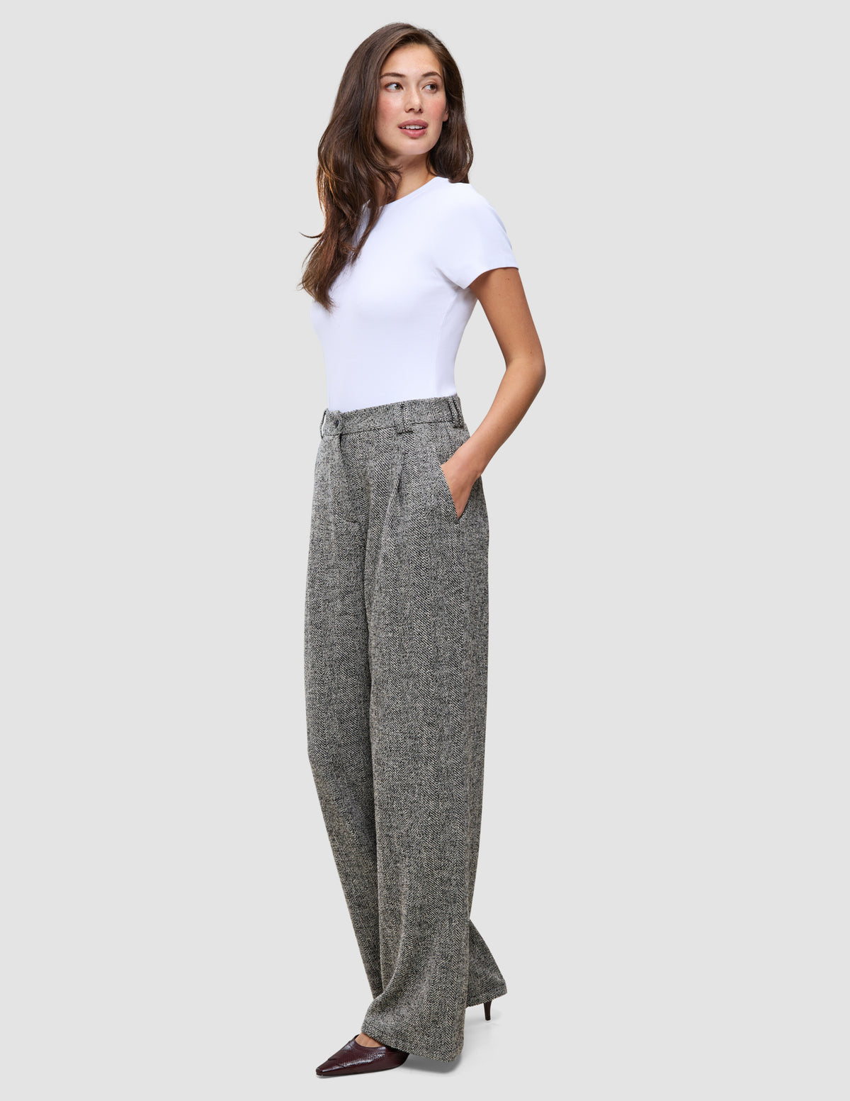 En kvinna klädd i en vit t-shirt och gråa Women Ashryn Pants Wide Domino Herringbone med hög midja.