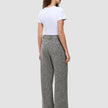 En person sedd bakifrån, klädd i en vit t-shirt och gråmönstrade Women Ashryn Pants Wide Domino Herringbone.