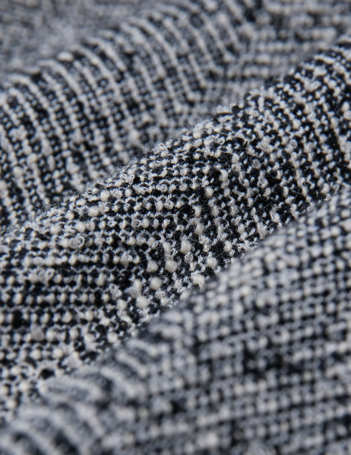 Närbild på byxorna Women Ashryn Pants Wide Domino Herringbone med ett svartvitt, strukturerat fiskbensmönster.