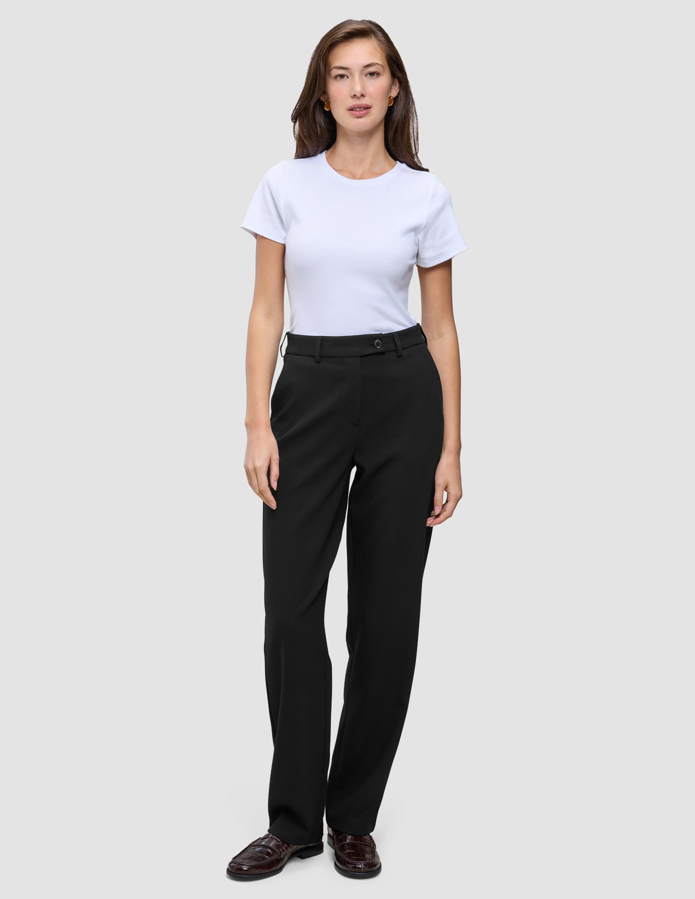 En person som bär en vit t-shirt och byxor av modellen Women GO2 Pants Straight Black med raka ben.