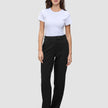 En person som bär en vit t-shirt och byxor av modellen Women GO2 Pants Straight Black med raka ben.