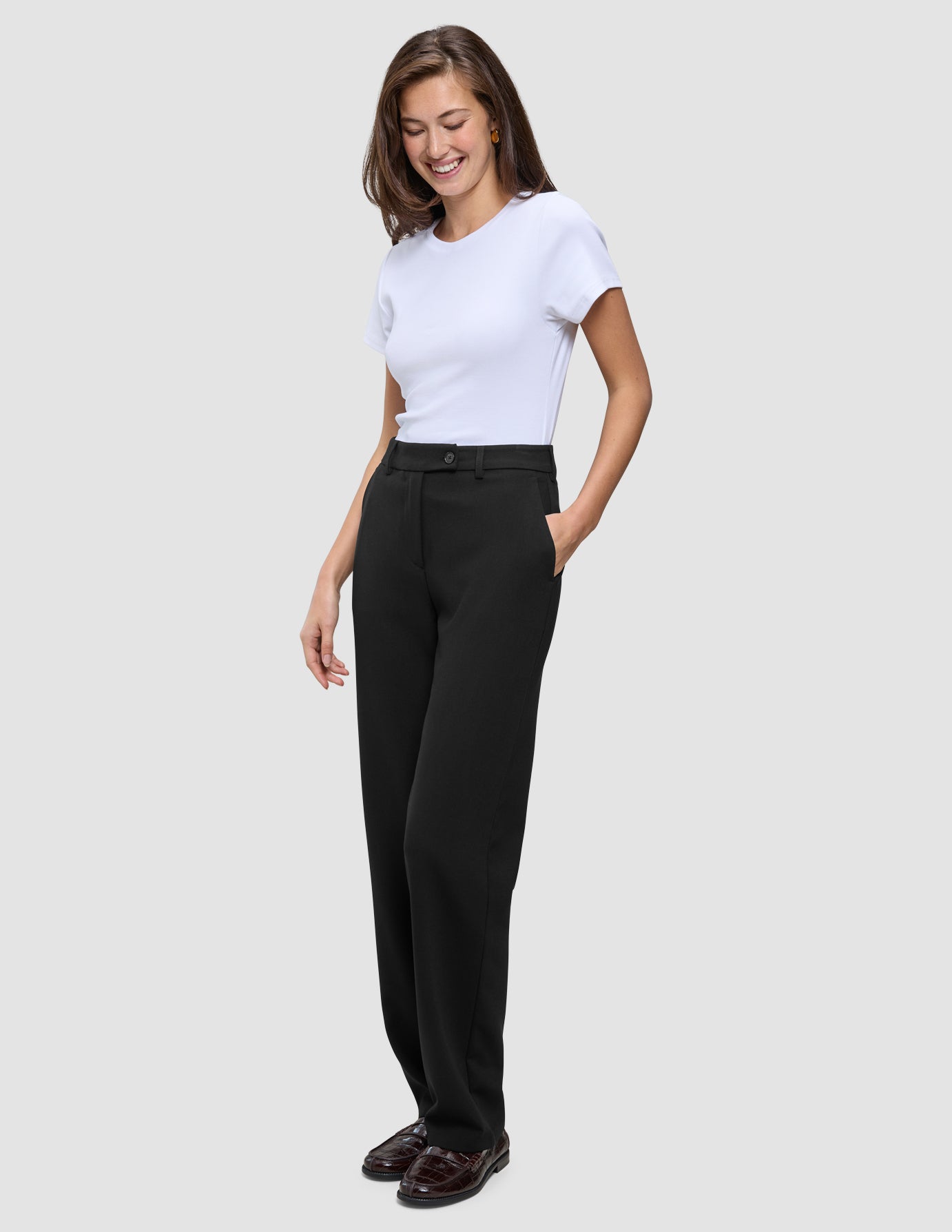 En kvinna klädd i en vit t-shirt, Women GO2 Pants Straight Black och loafers.