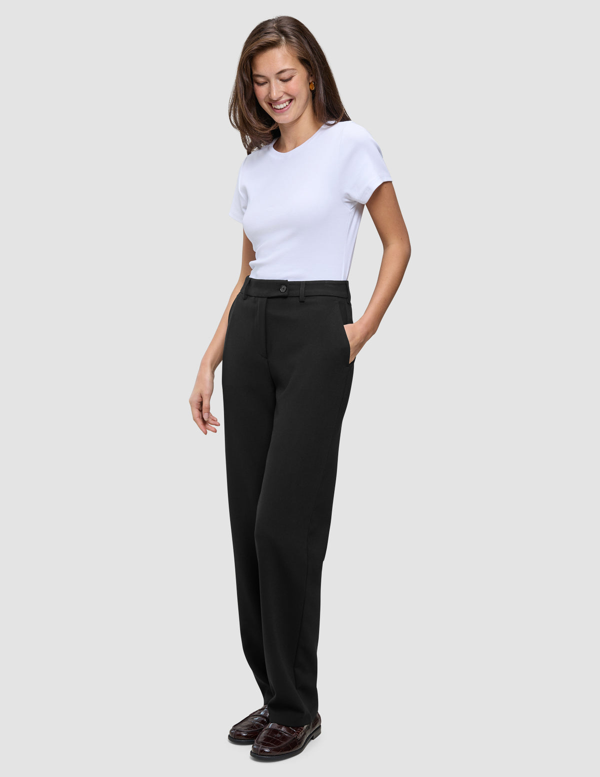 En kvinna klädd i en vit t-shirt, Women GO2 Pants Straight Black och loafers.