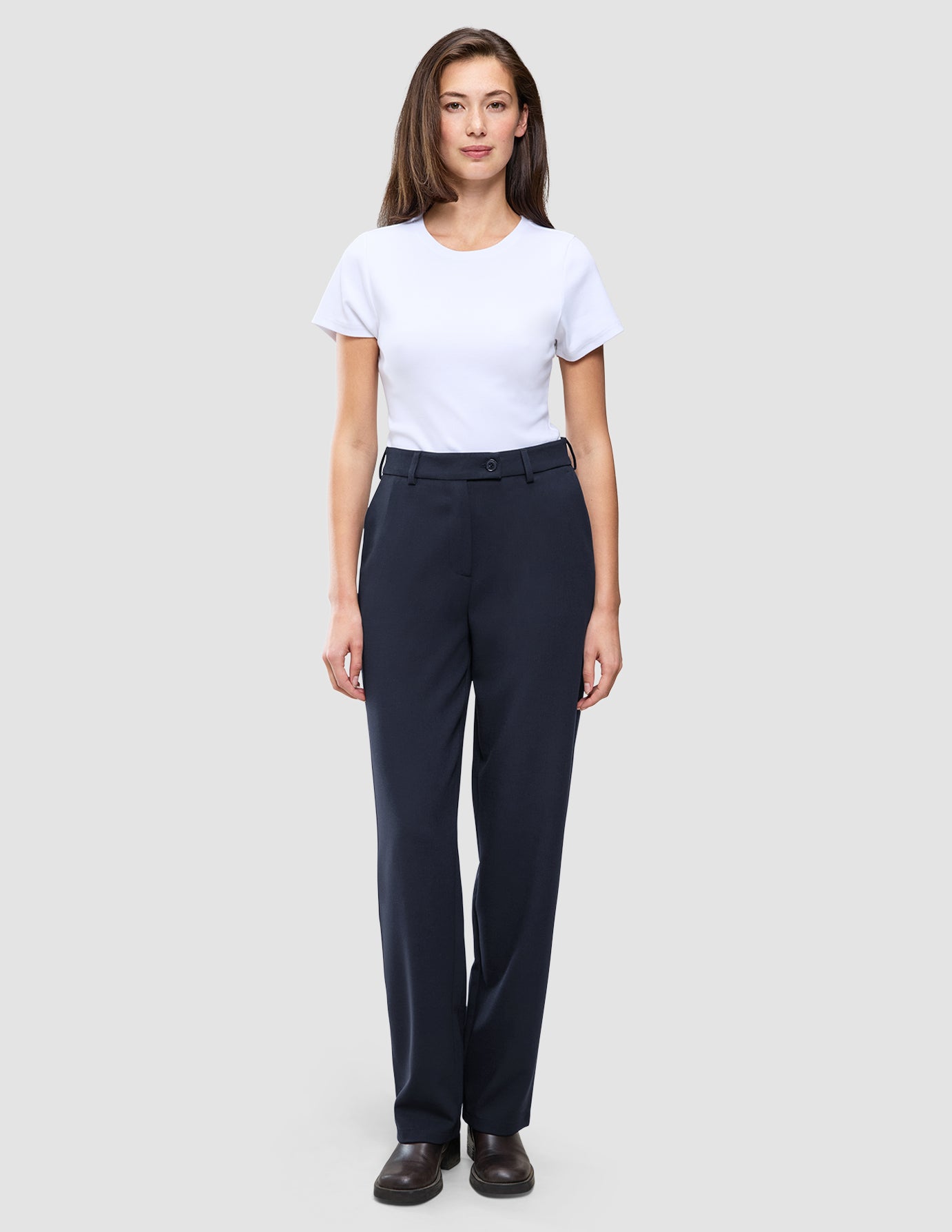 En kvinna bär en vit T-shirt med rund hals och byxor av modellen Women GO2 Pants Straight Blue Nights med raka ben i skandinavisk design.
