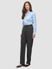 En kvinna i en ljusblå skjorta med knappar, svart bälte och byxor av modellen Women GO2 Pants Straight Dark Grey Melange i klassisk design.