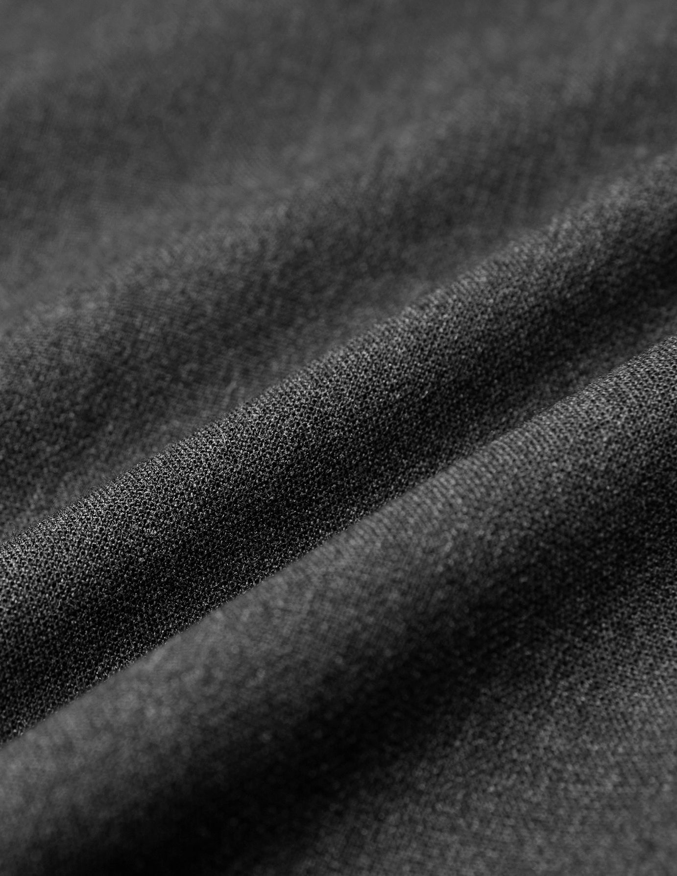 Närbild på veck i mörkgrå melerade Women GO2 Pants Straight-byxor med skandinavisk design.