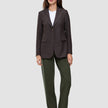 En mörkbrun blazer med smala ränder över en vit t-shirt, i kombination med Women GO2 Pants Straight Dusty Olive i klassisk design.