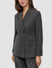 En kvinna bär en Women Nara Blazer Fitted Black Check, en skräddarsydd, svart- och vitrutig blazer med dubbelknäppning.