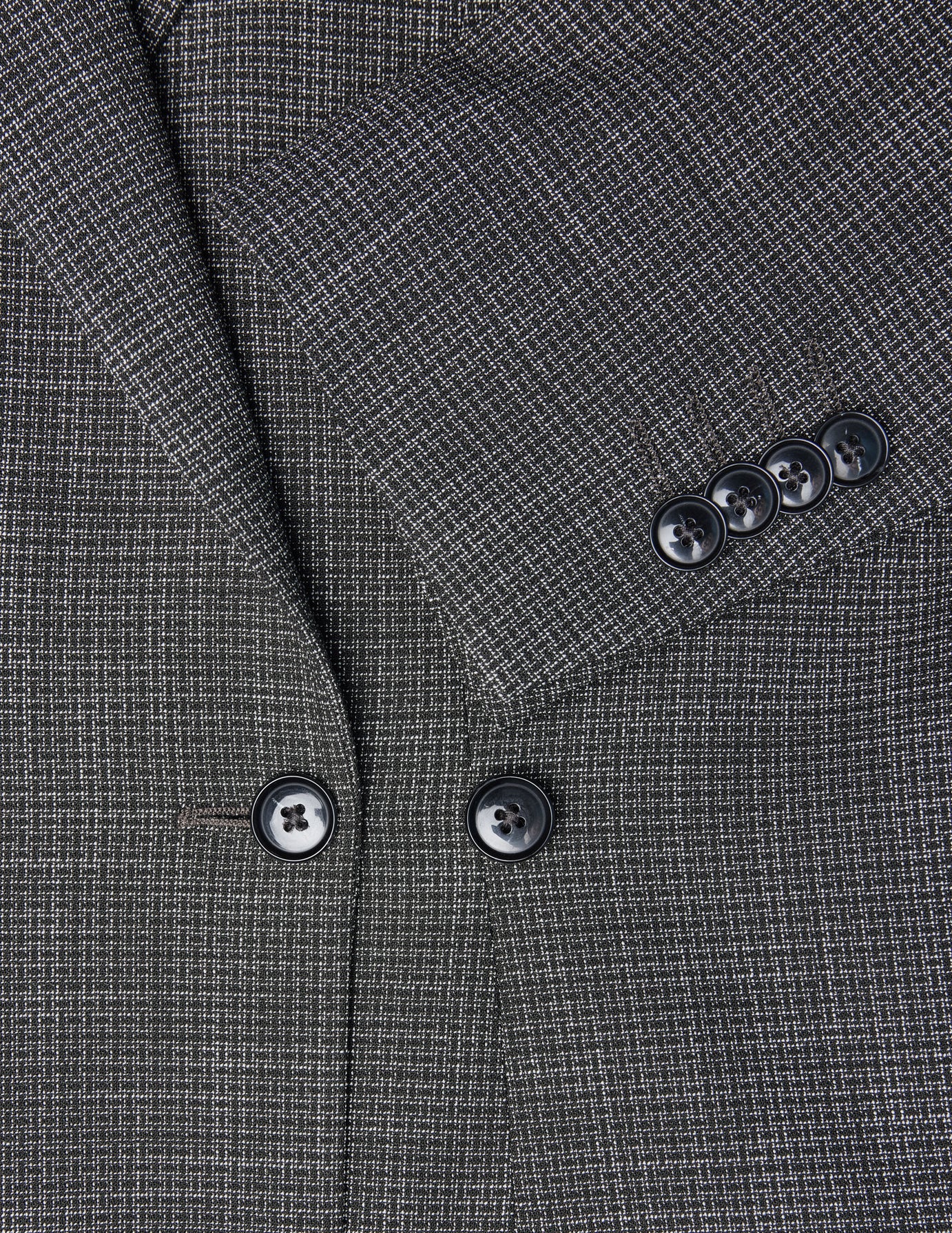Närbild på damblazern Nara Blazer Fitted Black Check i svartvitt rutmönster med svarta knappar.