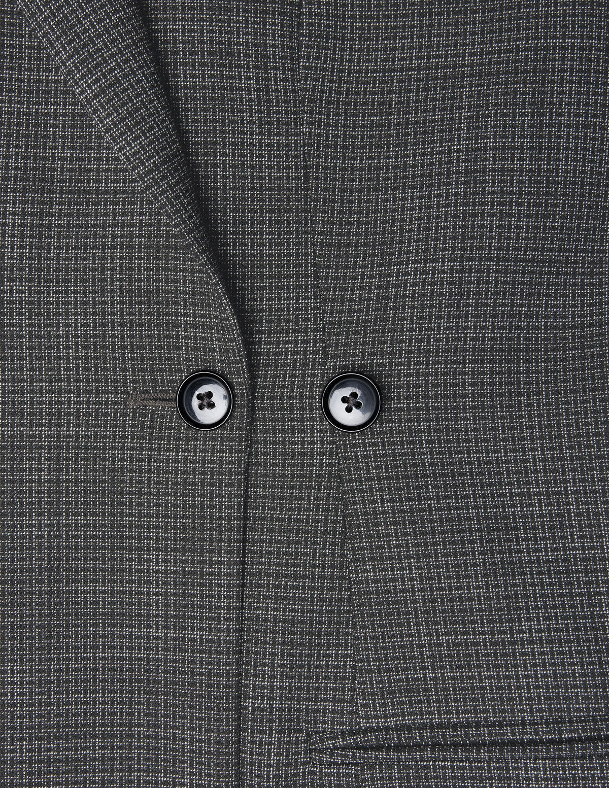 Närbild på Women Nara Blazer Fitted Black Check, en mörkgrå kavaj med ett diskret vitt rutmönster och två svarta knappar.