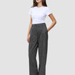 En person klädd i en vit t-shirt och ett par Women Nara Pants Wide Black Check med mörkgrått rutmönster.