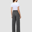 En kvinna sedd bakifrån, klädd i en vit t-shirt och byxor av modellen Women Nara Pants Wide Black Check med mörkgrå rutmönster.
