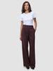 En kvinna bär en vit t-shirt och byxorna Women Serene Pants Wide Berry Pinstripe, som har vid ben och en minimalistisk design.
