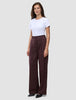 En person i en vit t-shirt och byxorna Women Serene Pants Wide Berry Pinstripe i mörkrött tyg med smala ränder.