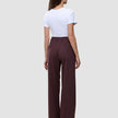 En person klädd i en vit t-shirt och byxorna Women Serene Pants Wide Berry Pinstripe med vid benvidd och ett mörkt bärfärgat mönster.