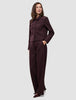 En kvinna bär en kort jacka av modellen Women Serene i färgen Berry Pinstripe tillsammans med matchande byxor med vida ben i skandinavisk design.