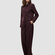 En kvinna bär en kort jacka av modellen Women Serene i färgen Berry Pinstripe tillsammans med matchande byxor med vida ben i skandinavisk design.