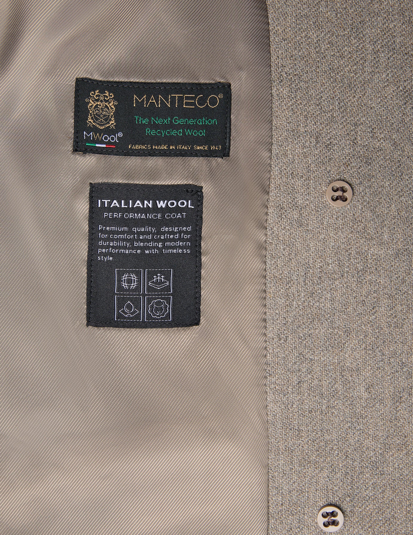 Etiketter inuti en gråbeige damrock i ull med Manteco-märkning för återvunnen och italiensk ull.